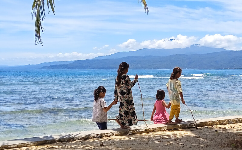 Children walking on Labuhan Jukung beach Krui Sumatra