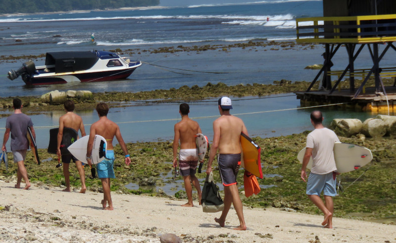 Surfers heading to The Peak from Labuhan Jukung beach